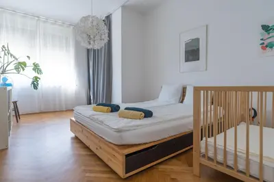 a small bedroom with a bed and a chandelier at Family apartment in the city centre - FREE parking garage in Ljubljana