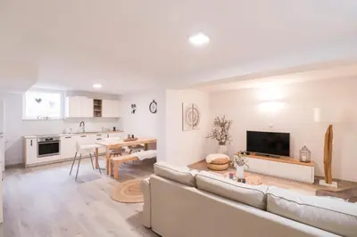 a white living room with a couch and a table at Apartment below Eden in Bled
