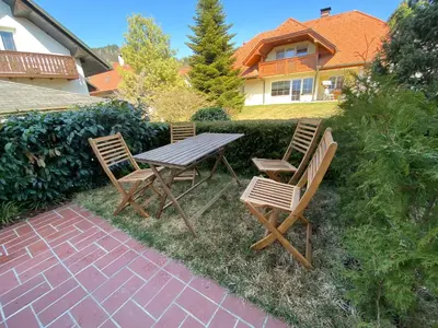 a picnic table and two chairs on a patio at Apartment below Eden in Bled