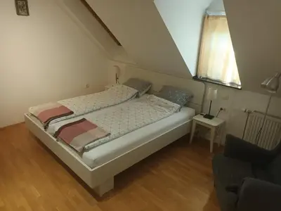 a large bed in a room with a window at House Trta in Ljubljana
