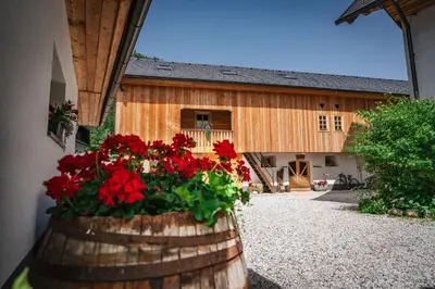 a barrel with flowers in front of a building at Country House Trata in Kranjska Gora