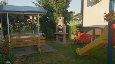 a playground with a pizza oven and a slide at Apartments Sončnica in Moravske Toplice