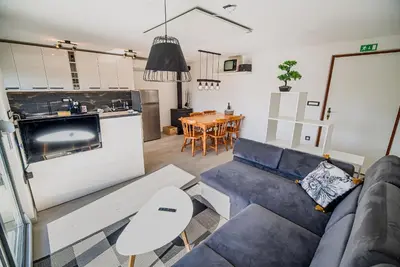 a living room with a blue couch and a kitchen at Holiday Home Aleks in Lendava