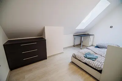 a bedroom with a bed and a dresser and a desk at Holiday Home Aleks in Lendava