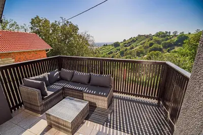 a patio with a couch and a table on a balcony at Holiday Home Aleks in Lendava