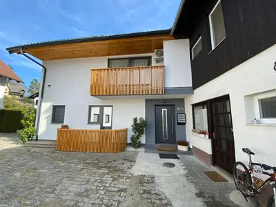 a white house with a balcony and a porch at BLED LAKE HOUSE - Apartment SKY in Bled