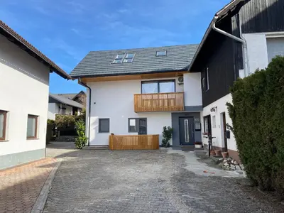 a white house with a black roof and a driveway at BLED LAKE HOUSE - Apartment SKY in Bled