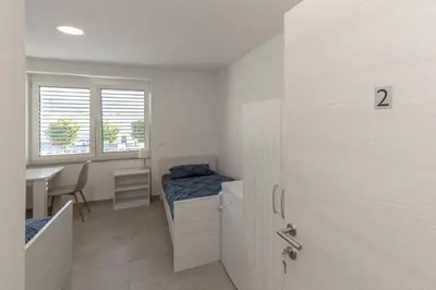 a small room with a bed and a table at RM Roma Studio in Celje