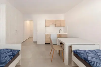 a kitchen and dining room with a table and chairs at RM Roma Studio in Celje