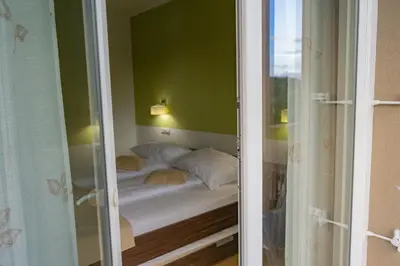 a bed in a room with a green wall at Apartmajska hiša Breza in Ribnica na Pohorju