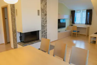 a living room with a table and a fireplace at Apartmajska hiša Breza in Ribnica na Pohorju