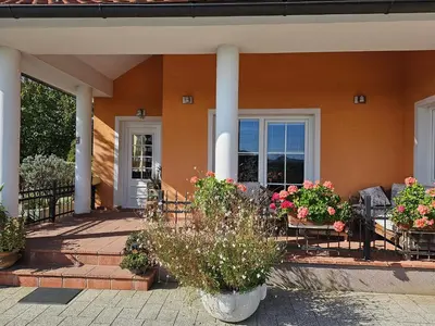 a porch of a house with flowers and plants at apartment AURORA in Rogaška Slatina