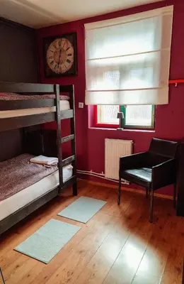a room with two bunk beds and a clock at Sax Pub Hostel Ljubljana in Ljubljana