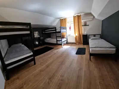 a room with two bunk beds and a wooden floor at Sax Pub Hostel Ljubljana in Ljubljana