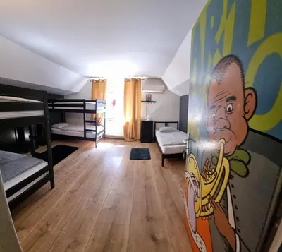 a room with bunk beds and a painting on the wall at Sax Pub Hostel Ljubljana in Ljubljana