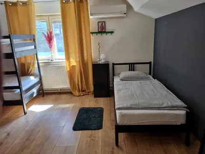 a bedroom with a bed and a ladder and a window at Sax Pub Hostel Ljubljana in Ljubljana