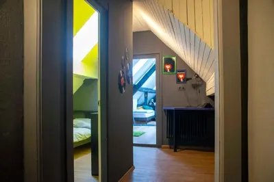 a hallway with a room with a bed and stairs at Sax Pub Hostel Ljubljana in Ljubljana