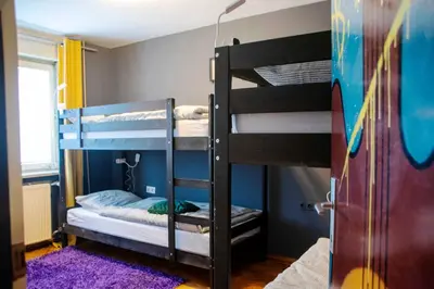 a bedroom with two bunk beds and a purple rug at Sax Pub Hostel Ljubljana in Ljubljana