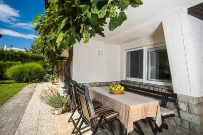 a table and chairs on a patio with a window at Apartments Poklukar in Bled
