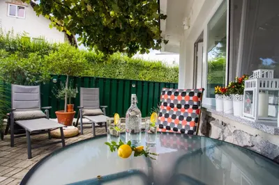 a glass table and chairs on a patio at Apartments Poklukar in Bled