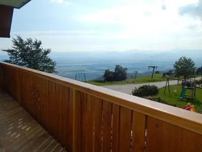 a wooden balcony with a view of a playground at Guest house Pr Ambružarju & Apartments in Cerklje na Gorenjskem