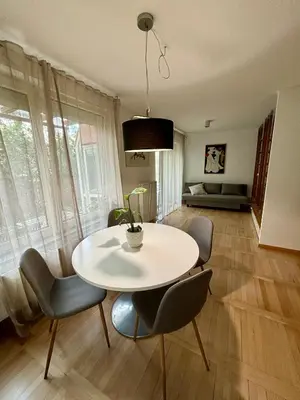 a dining room with a table and chairs and a room with a couch at Comfy flat in city-FREE parking in Ljubljana
