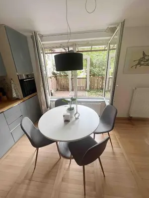 a white table and chairs in a kitchen with a window at Comfy flat in city-FREE parking in Ljubljana