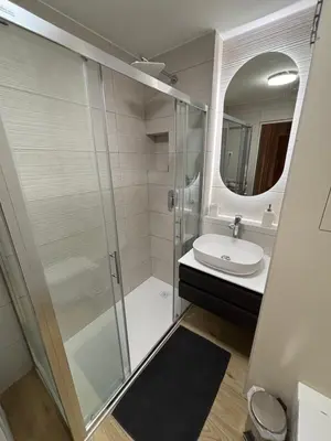a bathroom with a shower and a sink and a mirror at Comfy flat in city-FREE parking in Ljubljana