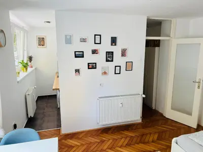 a room with a white wall with pictures on it at Paula’s cosy place in the center of Ljubljana in Ljubljana