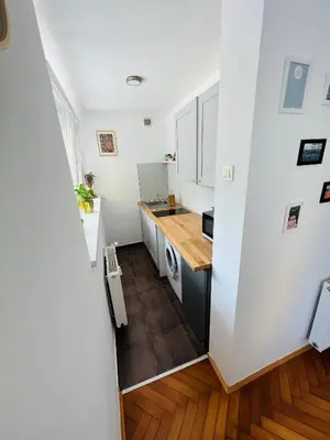 a small kitchen with white walls and wooden floors at Paula’s cosy place in the center of Ljubljana in Ljubljana