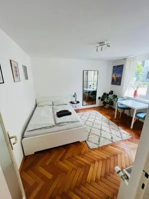a bedroom with a bed and a wooden floor at Paula’s cosy place in the center of Ljubljana in Ljubljana