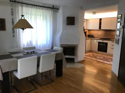 a kitchen and living room with a table and chairs at Holiday Home Anja in Bohinj