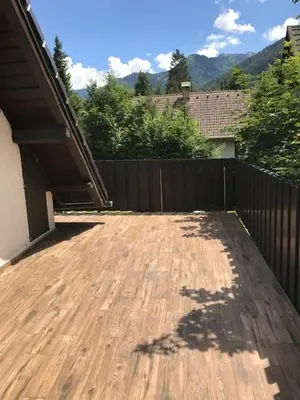 a backyard with a wooden deck with a fence at Holiday Home Anja in Bohinj