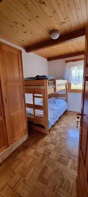 a bedroom with a bunk bed and a wooden ceiling at Marinčeva zidanica in Črnomelj