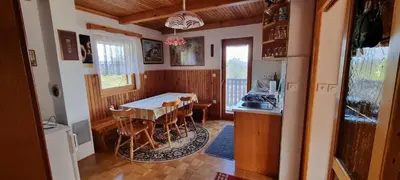 a dining room with a table and a kitchen at Marinčeva zidanica in Črnomelj