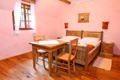 a bedroom with a bed and a table and chairs at Pomona Relaxing Nature Guest House in Rogaška Slatina