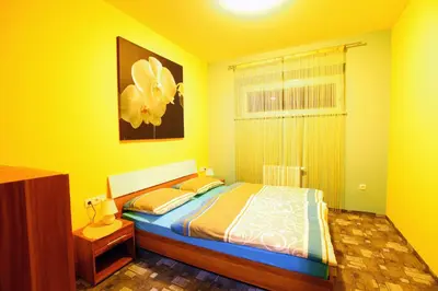 a yellow bedroom with a bed and a window at Apartments Pri Adamsovih in Čatež ob Savi