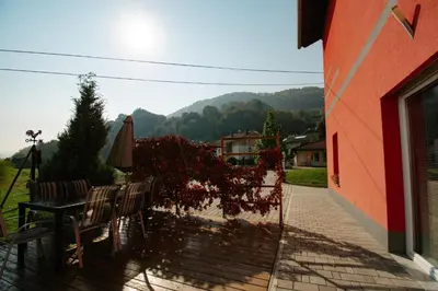 a patio with two chairs and a table and an umbrella at Apartments Pri Adamsovih in Čatež ob Savi
