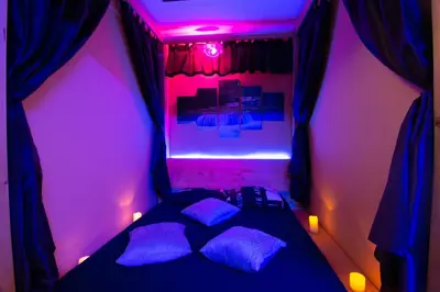 a bedroom with purple lighting and a bed with pillows at Apartments Pri Adamsovih in Čatež ob Savi
