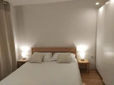 a bedroom with a bed with two lamps on two tables at Apartment Kenda in Bovec
