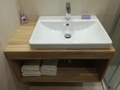 a bathroom with a sink and towels on a shelf at Apartment Kenda in Bovec