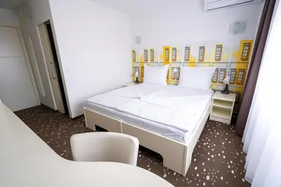 a small room with a bed and a chair at City Hotel Krško in Krško