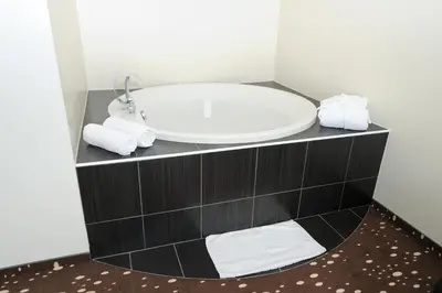 a bathroom with a sink and a bath tub at City Hotel Krško in Krško