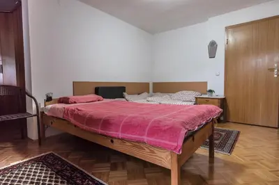 a bedroom with a large bed with a pink blanket at Apartment Satya in Dobrna