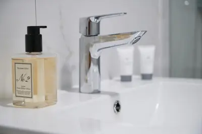 a bathroom sink with a bottle of soap and a faucet at Posestvo Gjerkeš in Rogašovci
