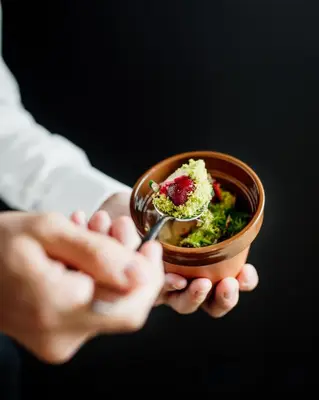 a person holding a bowl of food with a fork at Posestvo Gjerkeš in Rogašovci
