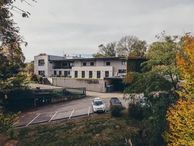 a car parked in a parking lot in front of a building at Posestvo Gjerkeš in Rogašovci