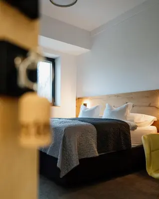 a hotel room with a bed with white pillows at Posestvo Gjerkeš in Rogašovci