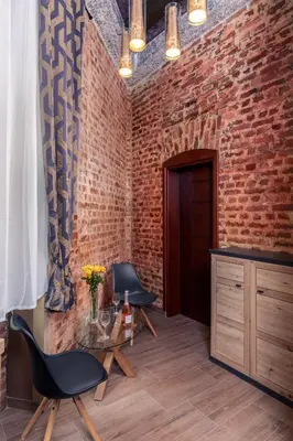 a brick room with two chairs and a glass table at Villa Sofija in Ljubljana