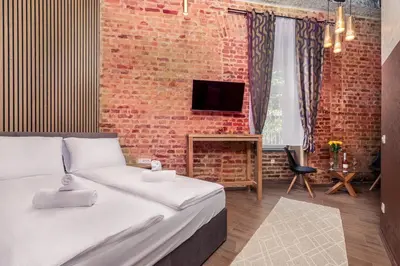 a bedroom with a bed and a brick wall at Villa Sofija in Ljubljana